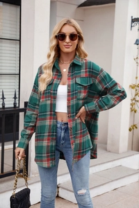 Detail of oversized green and red plaid flannel shirt featuring dual chest flap pockets