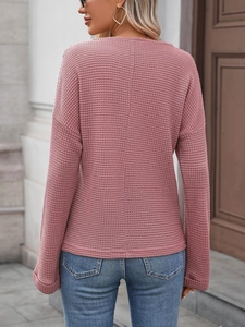 Dettaglio della maglia a nido d'ape sul top rosa a maniche lunghe con spalla scesa