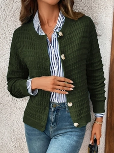 Detail of dark green knit cardigan with waffle texture and white pearl-like buttons