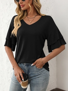 Detail of black V-neck top showing double-layered ruffle sleeves and ribbed texture fabric