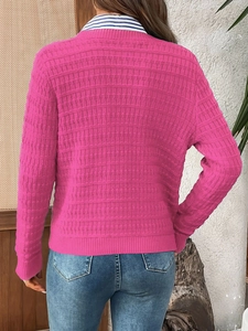 Rear view of vibrant pink knit cardigan featuring vertical ribbed texture and layered styling