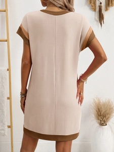 Back view of a beige waffle knit dress featuring brown contrast trim in a minimalist setting