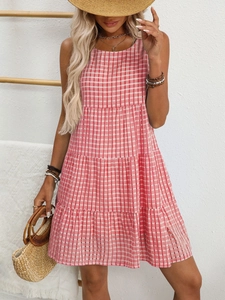 Detail of red and white checkered sleeveless tiered summer dress on model for vacation