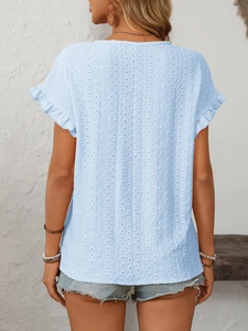 Vue détaillée de la broderie ajourée bleu clair et des manches à volants du t-shirt