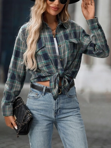 Detail of green and blue plaid flannel shirt with front flap pockets and button-down collar