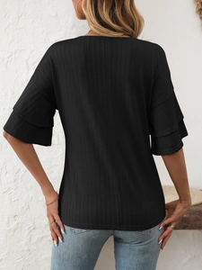 Detail of the back view of a black ribbed knit top with layered ruffle sleeves for women