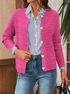 Detailed macro view of rose pink waffle knit texture and white buttons on the cardigan
