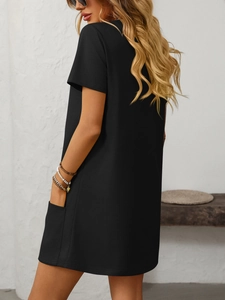 Detail view of a black short-sleeve dress showing a functional side pocket and clean cut
