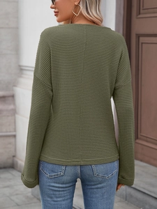 Dettaglio della maglia a nido d'ape su un top a maniche lunghe verde militare da donna