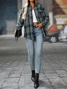 Close-up of classic green plaid flannel shirt styled with light blue jeans and black boots