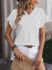 Detail of white V-neck ribbed knit short sleeve top with drop shoulders and loose fit design