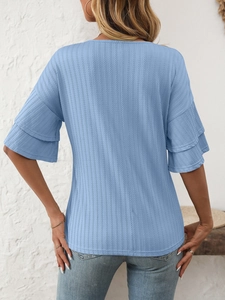 Detail view of light blue V-neck top with ruffled sleeves and vertical stripe texture