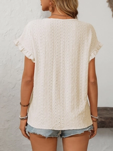 Détail du haut en coton blanc avec broderie anglaise et manches volantées