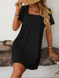 Detail of a black square neck mini dress featuring short sleeves and front patch pockets