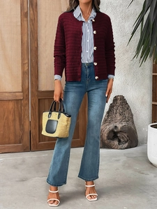 Close-up of burgundy knit cardigan with textured checks and elegant gold round buttons