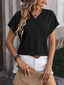 Close-up of black V-neck rib-knit top featuring textured vertical stripes and elegant draped fit