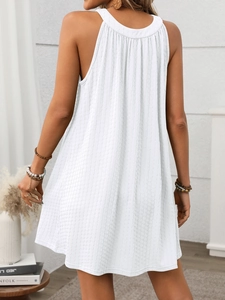 Detail view of the pleated halter neckline and vertical texture on a white summer dress