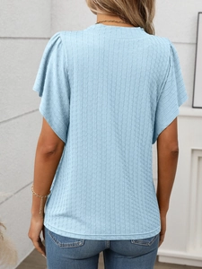 Détail du t-shirt bleu clair plissé montrant la texture verticale et les manches volantées