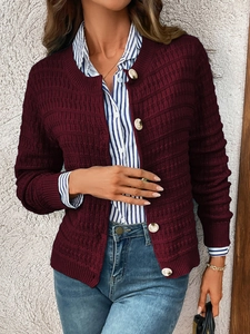 Detail of dark burgundy knit cardigan with textured wave pattern and white buttons