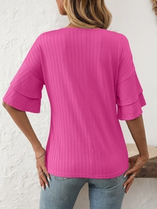 Detail of fuchsia ribbed knit top featuring double-layered ruffle sleeves and texture
