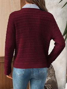 Detail of burgundy knit cardigan featuring a textured grid pattern and ribbed cuffs