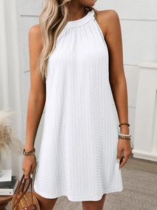 Detail of white sleeveless halter dress with pleated texture and bohemian resort style