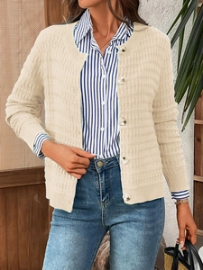 Detail of beige knit cardigan texture with elegant pearlescent buttons and soft ribbed fabric