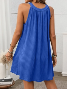 Detail view of the pleated back design and textured fabric on a blue halter dress
