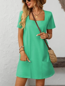 Close-up of a green square neck short sleeve dress featuring functional front pockets