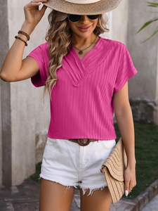 Detail of fuchsia ribbed knit top featuring V-neckline and vertical textured fabric