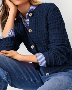 Detail of dark blue waffle knit cardigan with vintage wooden buttons and textured fabric