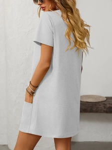 Detail view of light grey short-sleeved dress with side pockets and smooth fabric