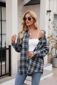 Detail of grey oversized plaid shirt showing soft fabric texture and buttoned cuffs