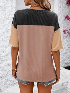 Detail of color-block waffle knit T-shirt showing black, pink, and khaki fabric textures