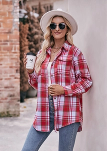 Detail of soft red and grey plaid flannel shirt featuring breast pocket and button closure