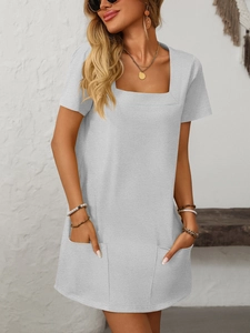 Detail shot of a light gray square neck dress featuring large functional patch pockets