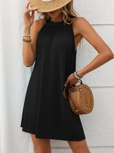 Close-up of black sleeveless halter mini dress showing vertical pleated fabric texture