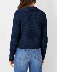 Detail view of navy waffle knit texture and ribbed hem on back of a women sweater