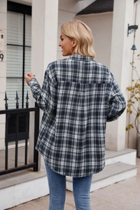 Back view of a long-sleeved oversized black and white plaid shirt with curved hem