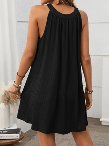 Back view of black halter neck dress showing pleated fabric texture and open back style