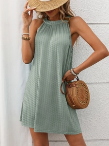 Detailed macro view of the light green halter neck dress showing textured vertical fabric