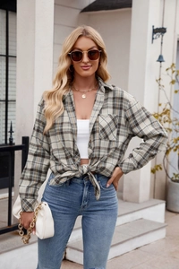 Detail of a casual long-sleeve plaid shirt tied at the waist with a stylish knot design