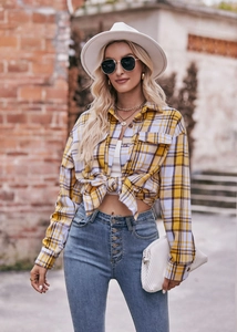 Detail of oversized yellow and purple plaid shirt with front pocket and tied hem