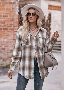 Detail of oversized plaid shirt jacket featuring amber buttons and flap chest pockets