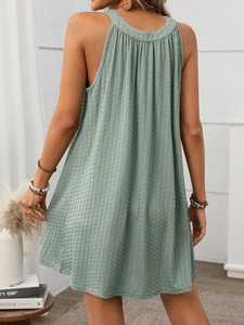 Detail view of the halter neck and pleated back on a sage green sleeveless summer dress