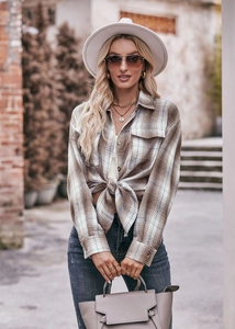 Detail view of stylish oversized plaid shirt for women tied at the waist for a trendy fit