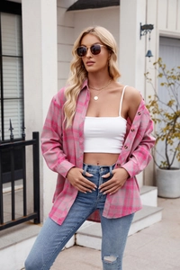 Women's plaid shirt paired with white crop top and ripped blue jeans in street style