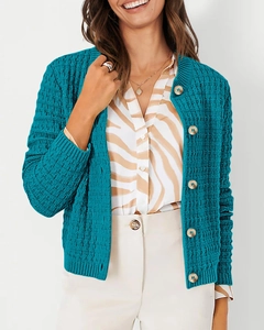 Detail of teal blue knit cardigan featuring waffle texture and gold embossed buttons