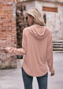 Detailansicht des weichen Strickstoffs und des geschwungenen Saums dieses rosa Hoodies