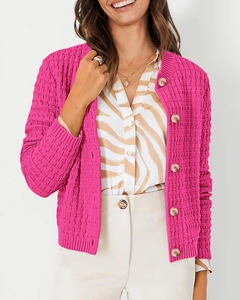 Detail of hot pink chunky knit cardigan showing rich texture and round brown buttons